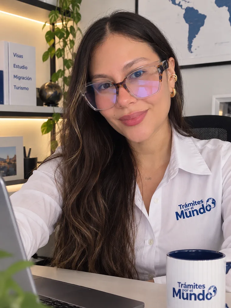 Consultora de Trámites por el Mundo en su escritorio, con computadora, libreta y pasaporte